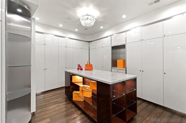 spacious closet featuring dark hardwood / wood-style flooring