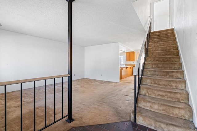 stairs featuring carpet and a textured ceiling