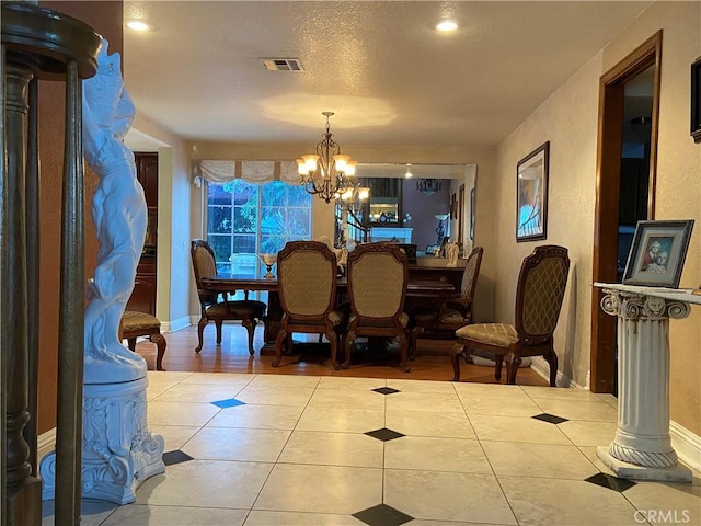 dining room with tile patterned flooring, visible vents, baseboards, decorative columns, and an inviting chandelier