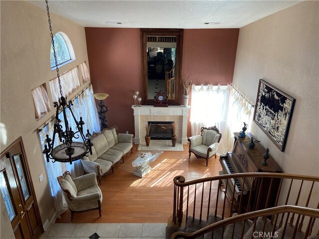 living room with light tile patterned flooring, a fireplace, and a high ceiling