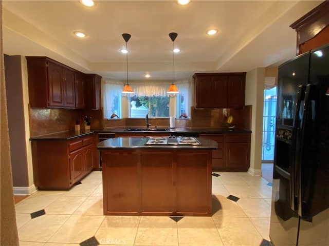 kitchen with dark countertops, stovetop with downdraft, black refrigerator with ice dispenser, a sink, and light tile patterned flooring