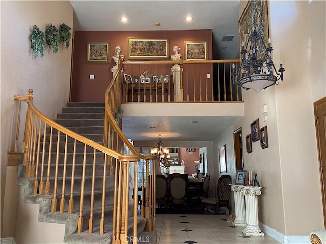 stairway featuring recessed lighting, visible vents, a high ceiling, and an inviting chandelier