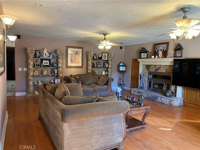 living area featuring a textured ceiling, a ceiling fan, and wood finished floors