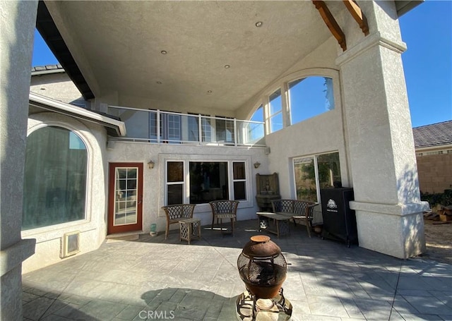 view of patio / terrace with a balcony and an outdoor fire pit