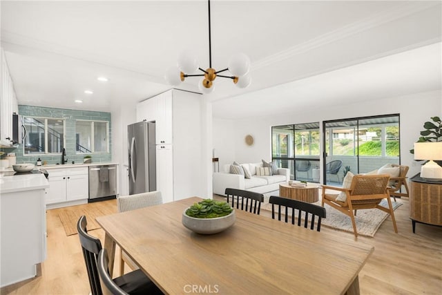 dining room with recessed lighting, light wood-style floors, a chandelier, and ornamental molding