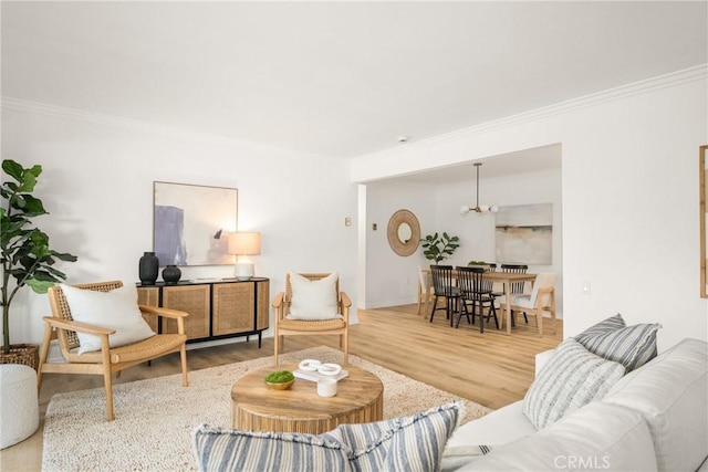 living area featuring crown molding, baseboards, wood finished floors, and a notable chandelier