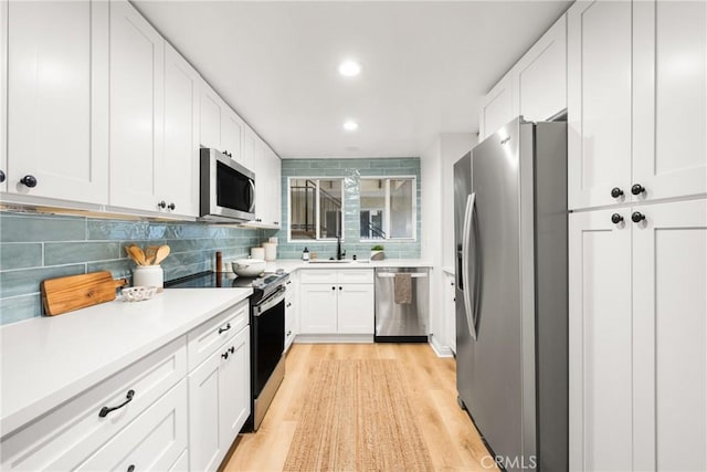 kitchen with white cabinetry, light countertops, tasteful backsplash, and stainless steel appliances