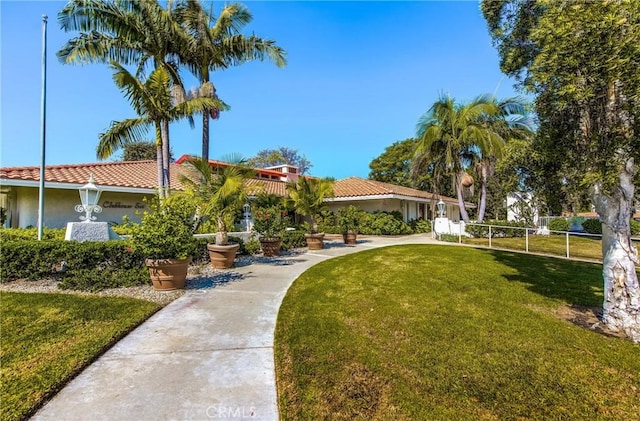 view of community featuring a lawn and fence