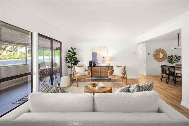 living room with ornamental molding, baseboards, and wood finished floors