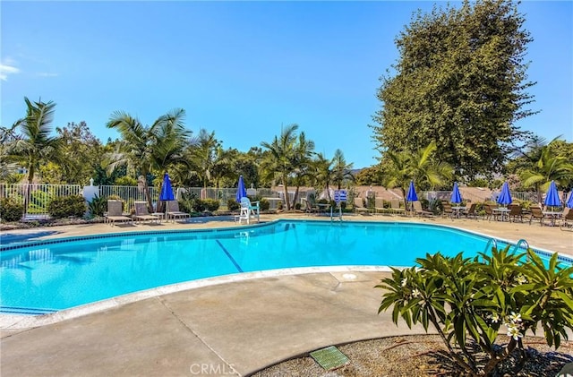 community pool with fence and a patio