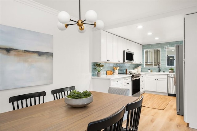 dining space featuring light wood-style floors, recessed lighting, and a notable chandelier