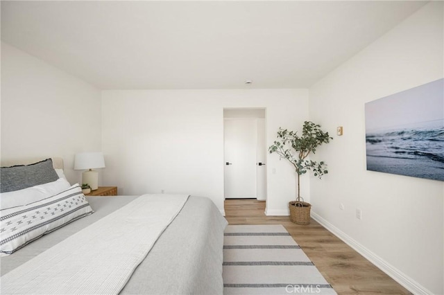 bedroom with baseboards and wood finished floors