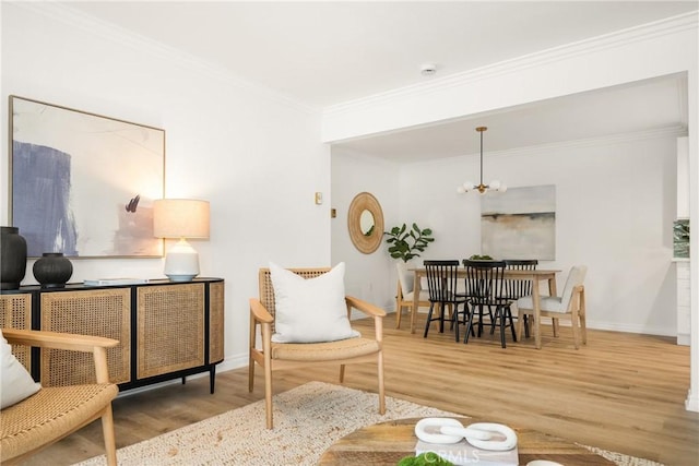 sitting room with baseboards, an inviting chandelier, ornamental molding, and wood finished floors