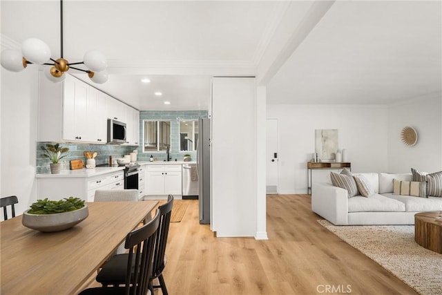 interior space with recessed lighting, ornamental molding, light wood-style flooring, and a notable chandelier