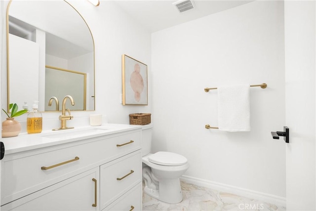 bathroom with vanity, toilet, marble finish floor, baseboards, and visible vents
