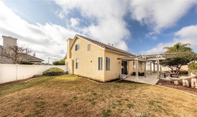 rear view of property with a lawn, a pergola, and a patio