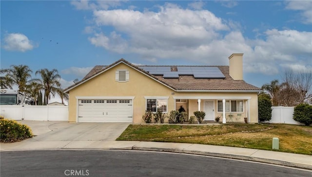 view of front facade featuring a front lawn, solar panels, and a garage