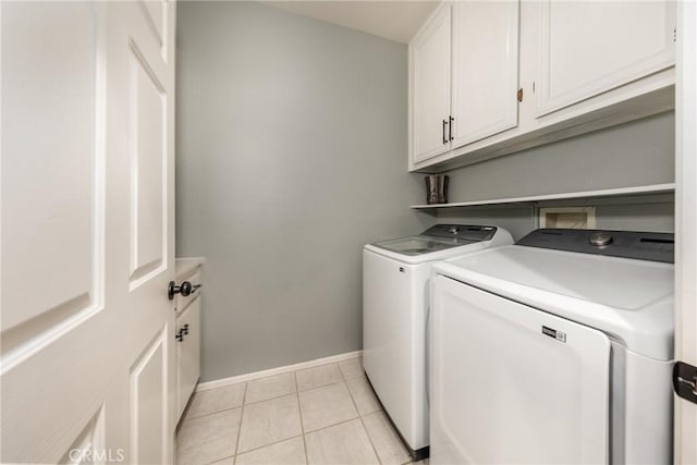 laundry area with cabinets, light tile patterned flooring, and washing machine and clothes dryer