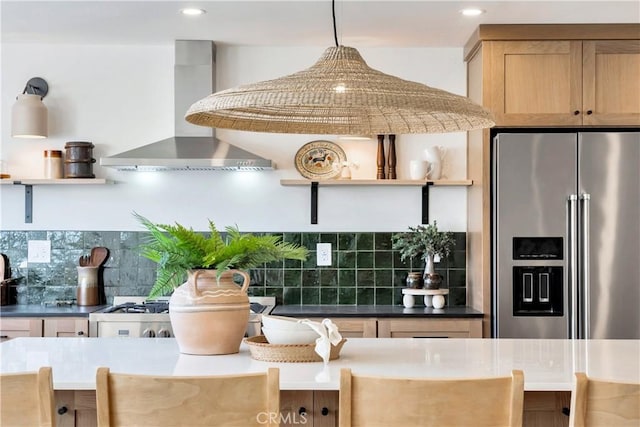 kitchen featuring high end fridge, backsplash, wall chimney range hood, and open shelves