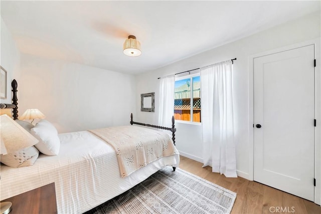 bedroom with wood finished floors and baseboards