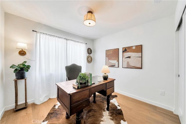 home office featuring light wood-style flooring and baseboards