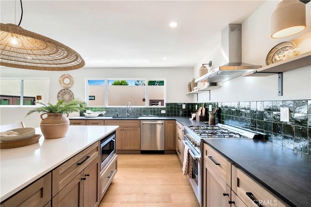 kitchen featuring tasteful backsplash, appliances with stainless steel finishes, island exhaust hood, open shelves, and a sink