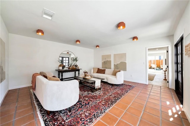 tiled living area featuring visible vents and baseboards