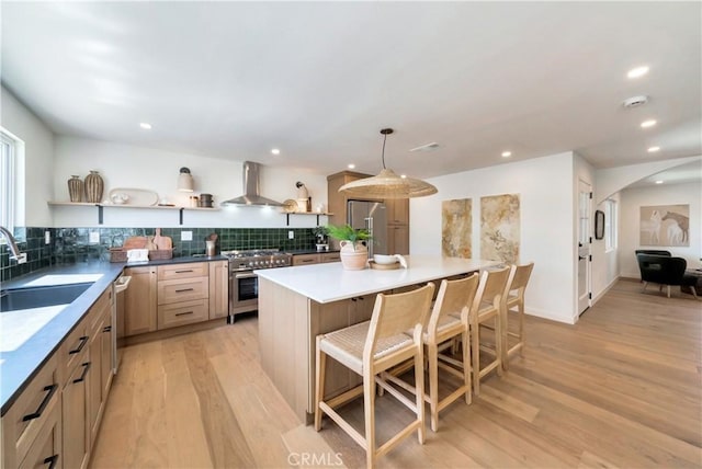 kitchen with arched walkways, wall chimney exhaust hood, stainless steel appliances, open shelves, and a sink