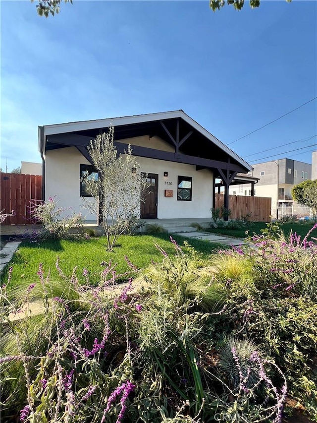 view of front of house featuring fence and stucco siding