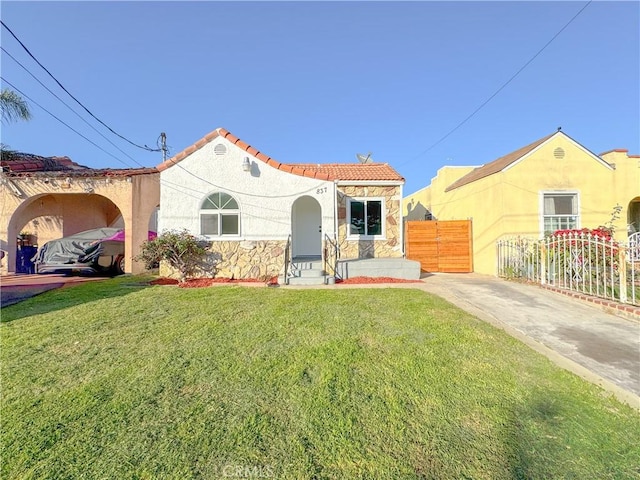 mediterranean / spanish home featuring a front lawn