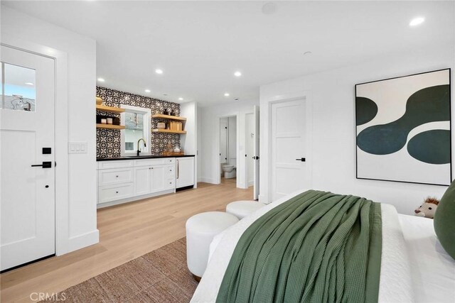 bedroom with light hardwood / wood-style flooring and sink