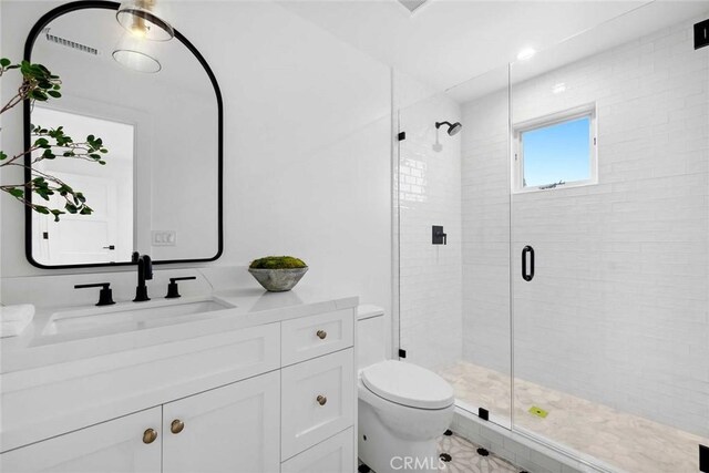 bathroom with toilet, an enclosed shower, and vanity