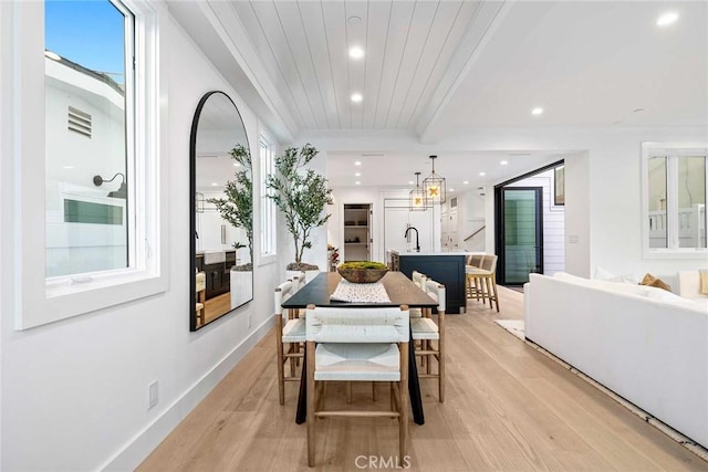 dining area with wooden ceiling, light hardwood / wood-style floors, and sink