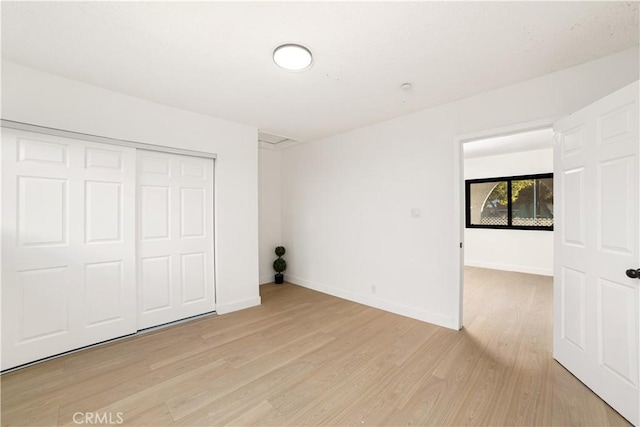 unfurnished bedroom with a closet and light hardwood / wood-style flooring