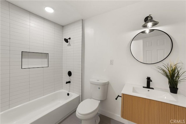 full bathroom featuring toilet, tiled shower / bath, and vanity