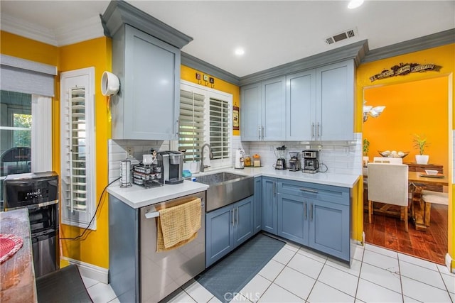 kitchen with light tile patterned floors, decorative backsplash, dishwasher, ornamental molding, and sink