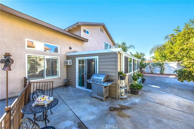 exterior space with a wall unit AC and a patio