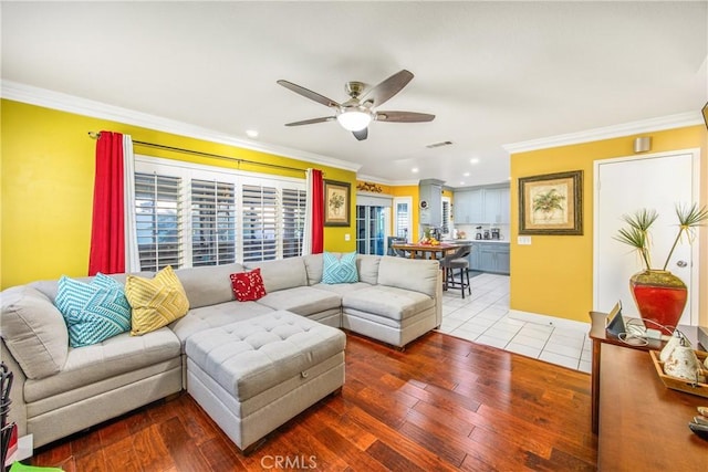 living room featuring hardwood / wood-style flooring, crown molding, and ceiling fan