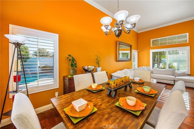 dining area with crown molding, hardwood / wood-style floors, and a notable chandelier