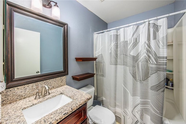 bathroom featuring toilet, vanity, and curtained shower