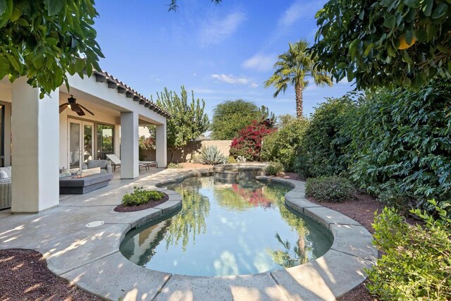 view of swimming pool with ceiling fan and a patio area