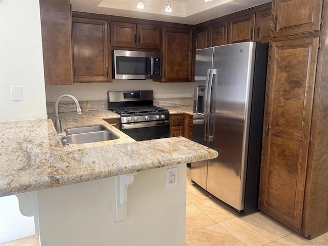 kitchen featuring kitchen peninsula, sink, a breakfast bar area, stainless steel appliances, and light tile patterned floors