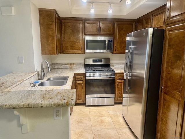 kitchen featuring appliances with stainless steel finishes, kitchen peninsula, a tray ceiling, and sink