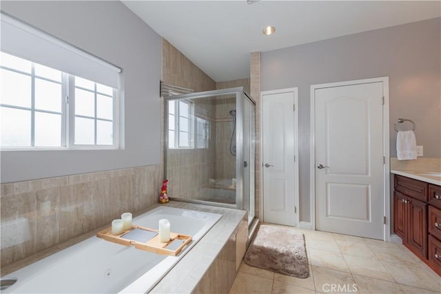 bathroom featuring independent shower and bath, tile patterned flooring, and vanity