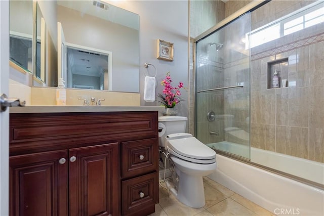 full bathroom featuring vanity, tile patterned flooring, combined bath / shower with glass door, and toilet