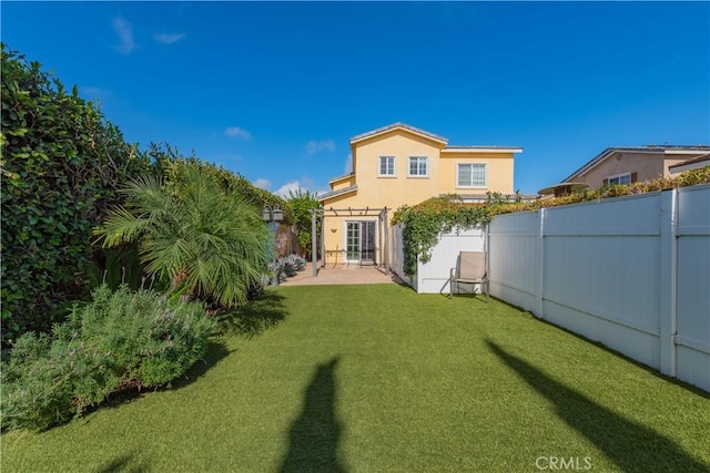 rear view of property featuring a lawn and a patio