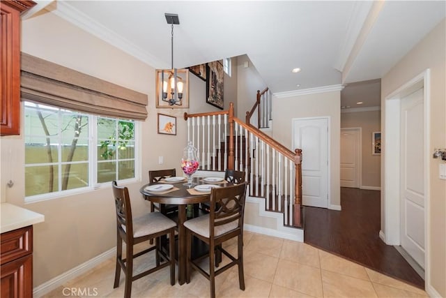 tiled dining room with a chandelier and ornamental molding