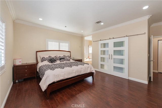 bedroom featuring a barn door, dark wood-type flooring, and crown molding