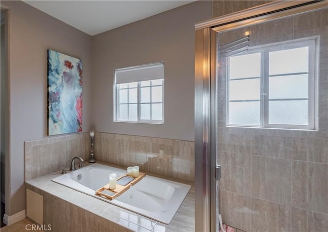 bathroom with shower with separate bathtub and a wealth of natural light