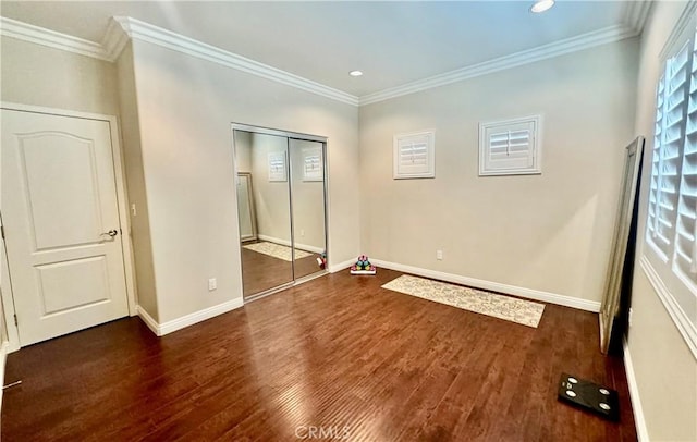 unfurnished bedroom featuring ornamental molding, dark wood-type flooring, and a closet